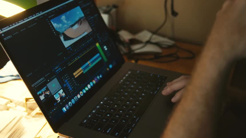 Man with headphones edits a video on his macbook pro