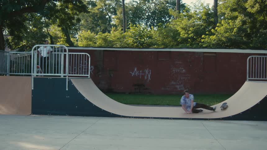 A skateboarder falling while skateboarding on a ramp
