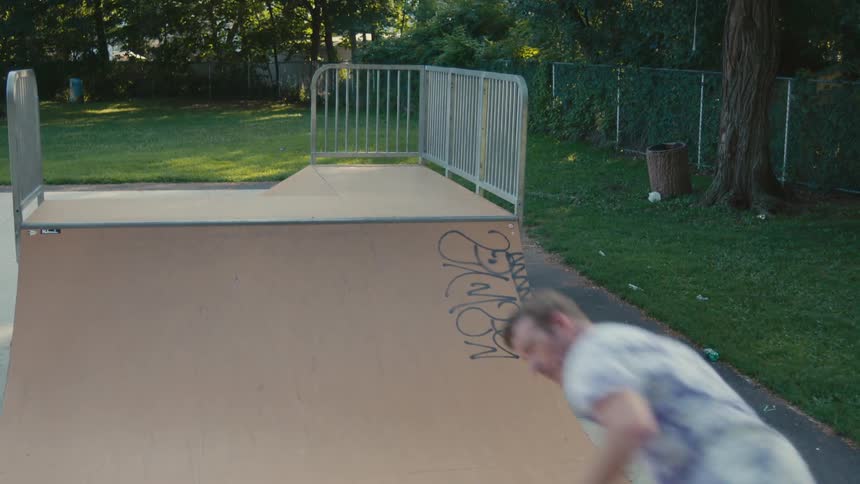 A man riding a skateboard on a ramp at a park