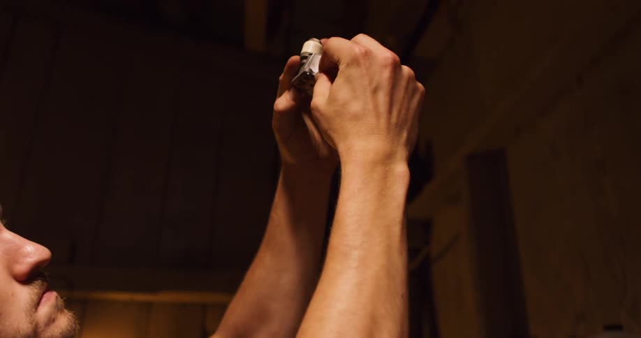 A man is working on something near a small work bench