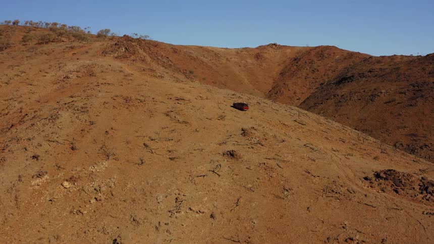 A four wheel drive crawls up the dirt hill