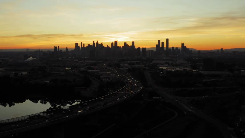 Traffic travels along a freeway outside of the center of a metropolis in the evening
