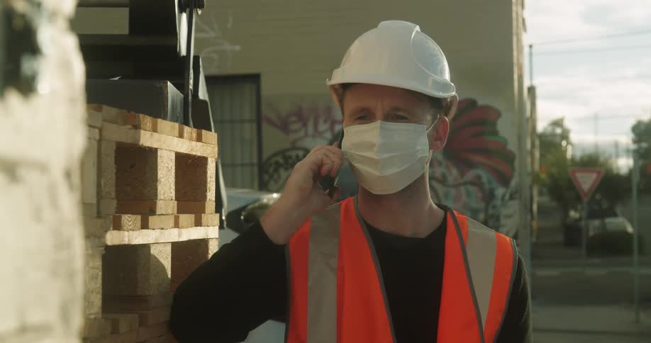 A worker is talking on a cell phone on a work site