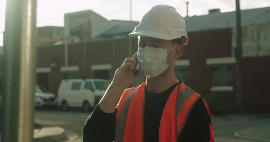 An employee talks on a cell phone as teenager cross a street
