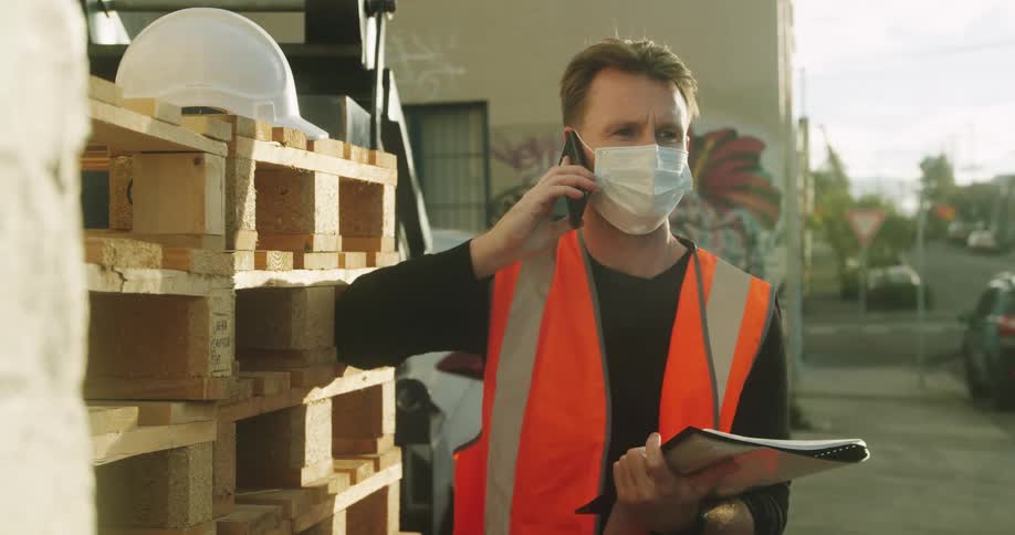 A man is talking on the cell phone at the work site