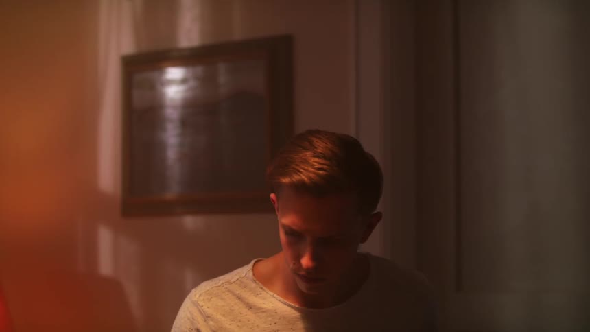 Male drummer plays a set of drums in a room