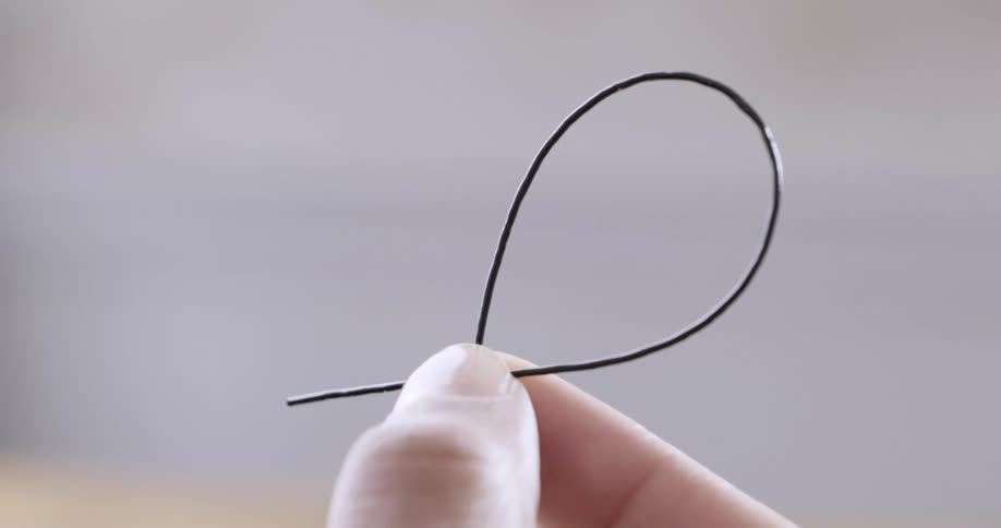 A person is holding a black wire