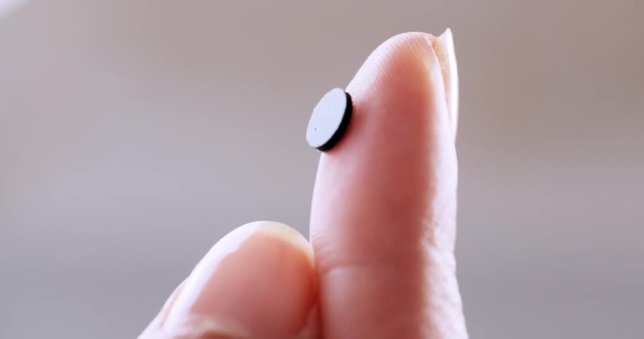 Small black disk clings to finger