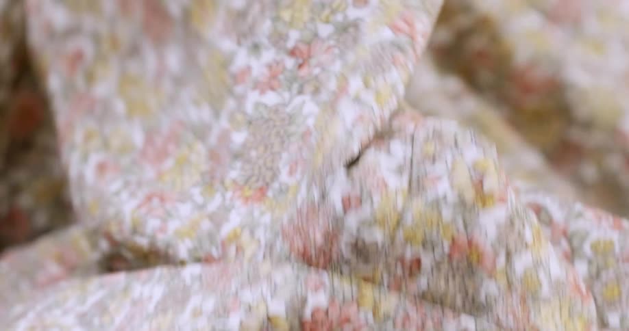 A womans hands as she holds material and examines it