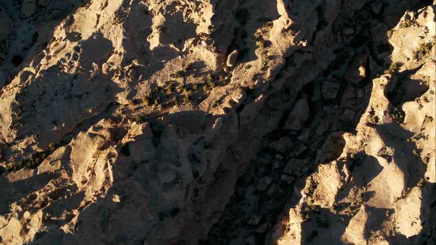 A ravine cloaked in a shadow in the badlands during the day