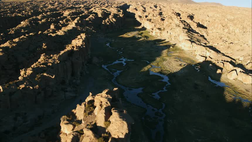 Rivers run past rough terrain under clear blue sky