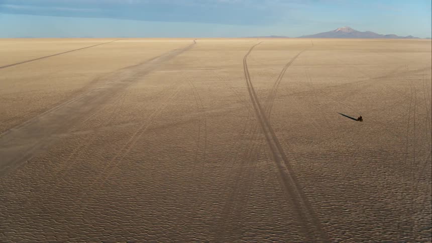 A person is riding a motorcycle through the desert