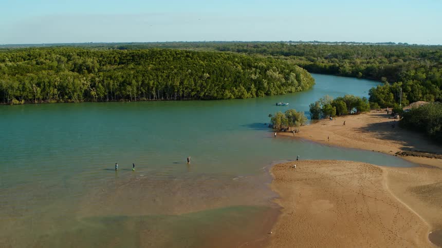 Aerial view of fishermen fishing with nets on a river near the jungle