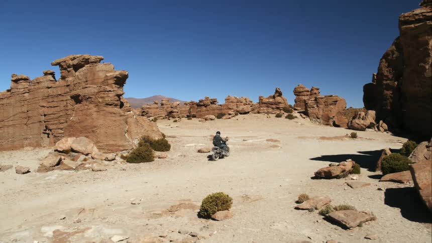A person drives their motorcycle in the desert