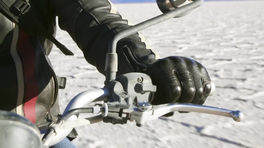 A person driving a motorcycle across a desert