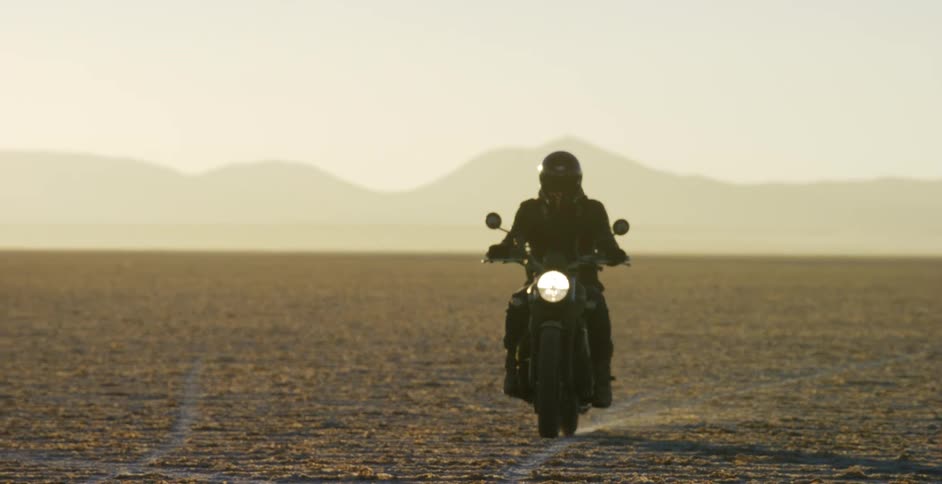 A person is riding a motorcycle through the desert