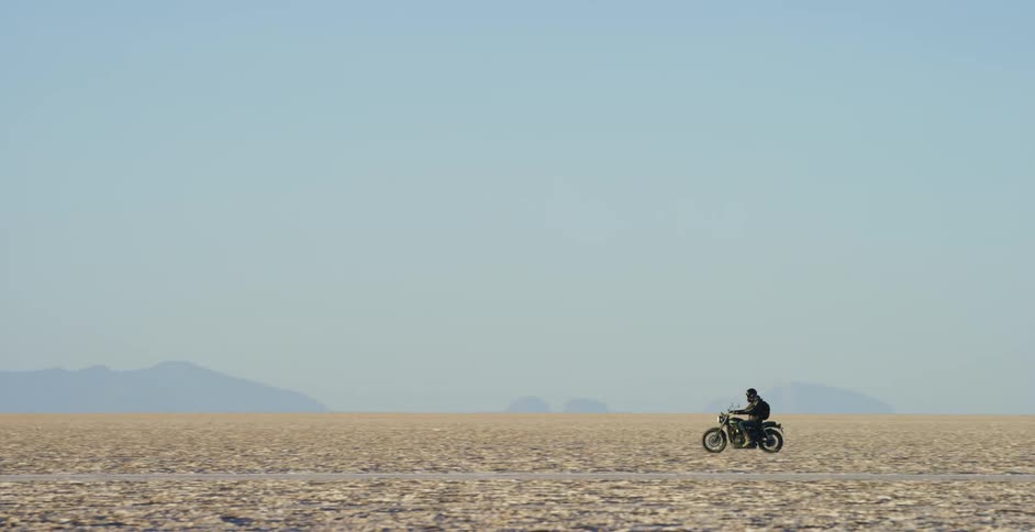 A person is riding a motorcycle through the desert