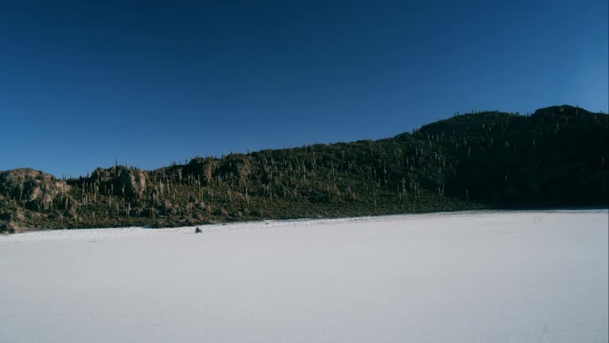 A person drives over the snow near the hills