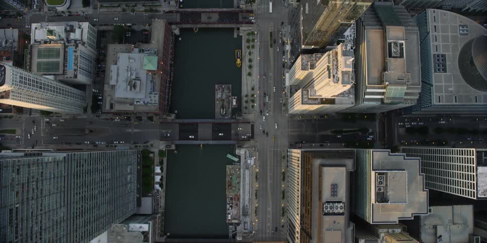 Aerial view of a city with tall buildings and cars driving below