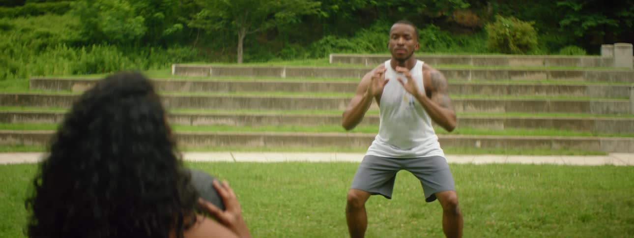 A man and woman toss a medicine ball back and forth