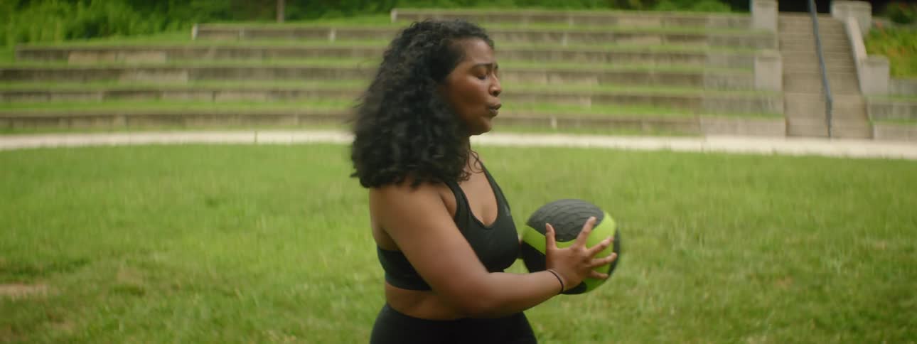 A woman is exercising with a medicine ball