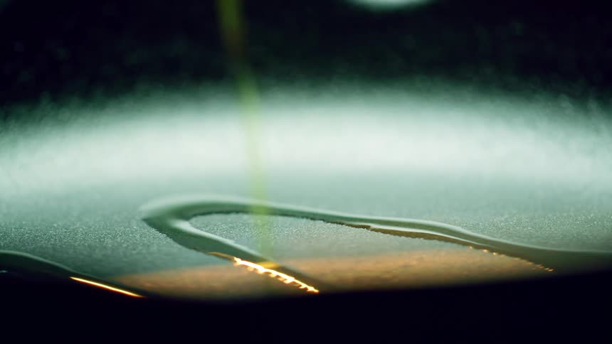 Oil is poured from a bottle into a skillet