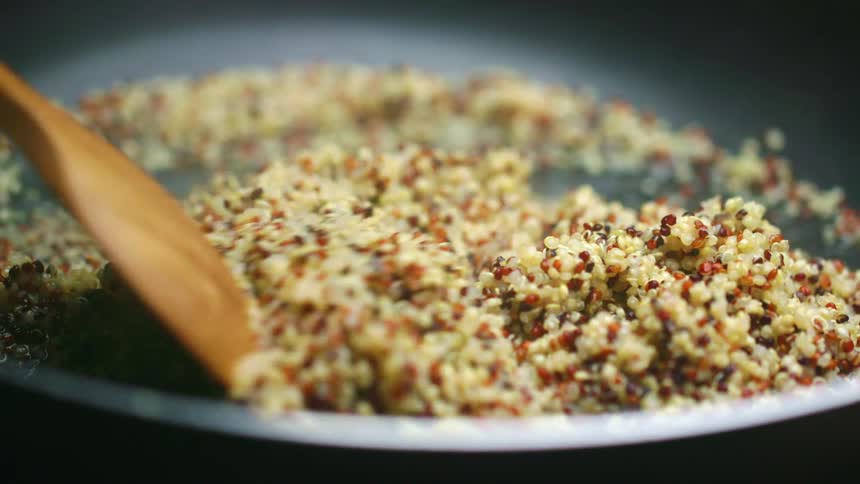 A person is stirring food in the pan