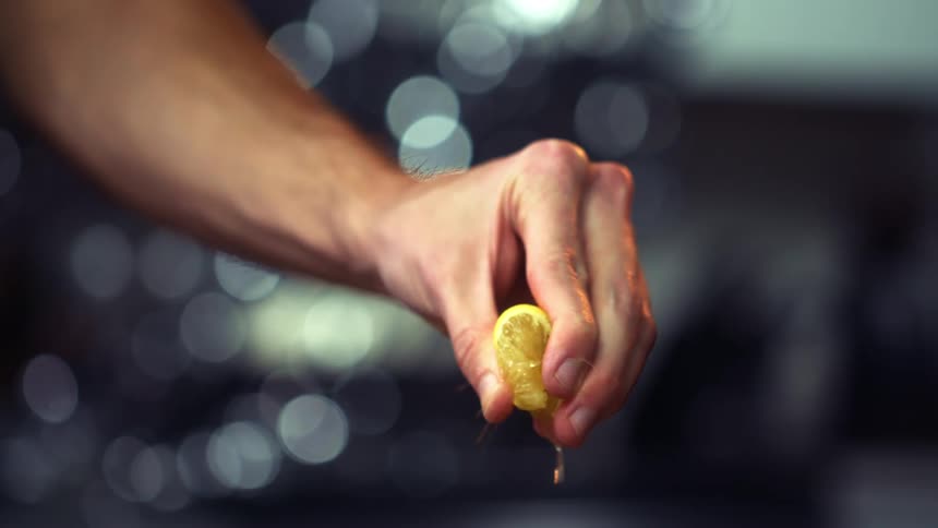 Hand squeezing lemon slice