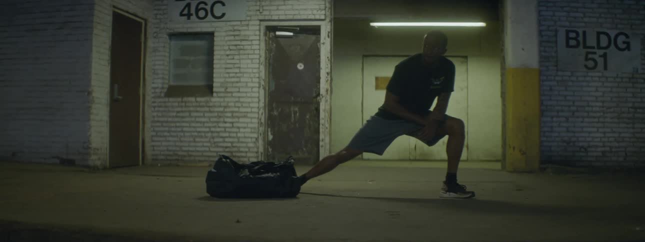A man is stretching outdoors at night