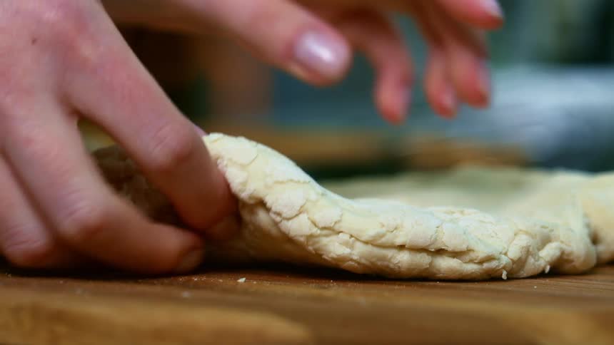 A person is preparing dough in the kitchen