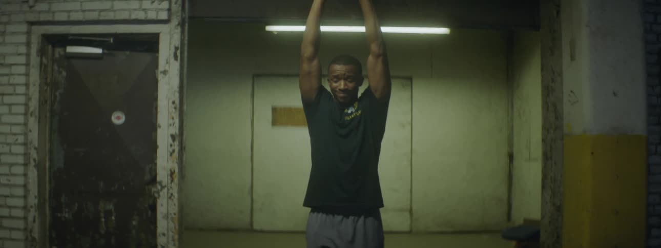 Young black man stretches his arms above head