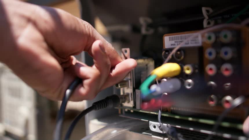 Human plugging something into a motherboard outdoors