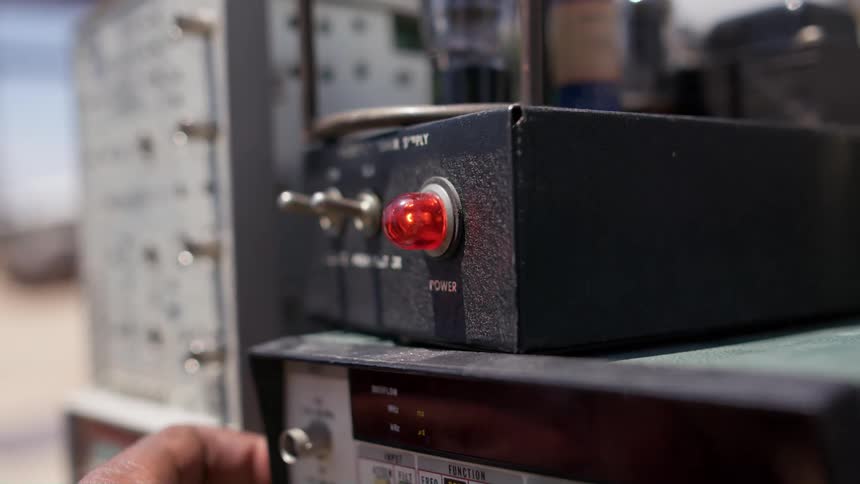 A person turning on switches on electric equipment