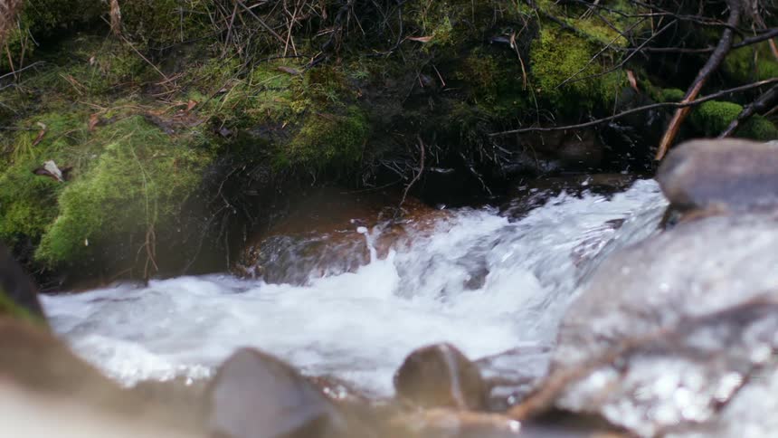 The stream pours over the large rocks