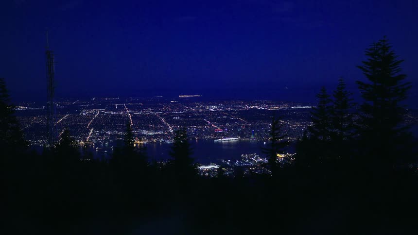 The city in the distance is bright from the mountain top