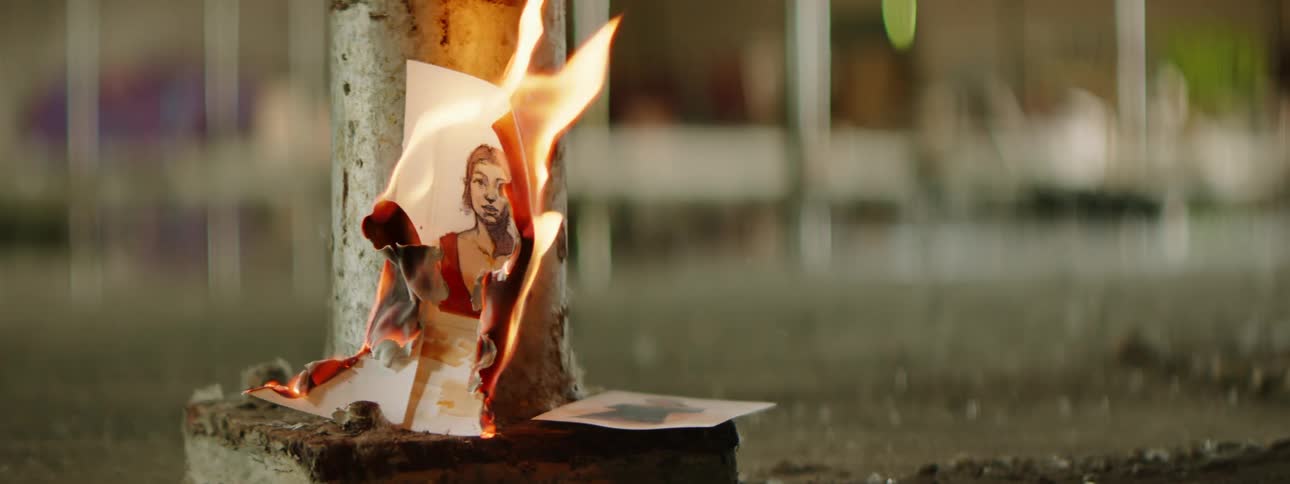 A picture hung on a post outdoors burns up in flames