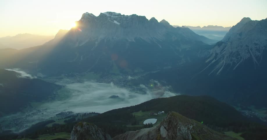 A town in a fog shrouded valley between tall mountain ridges