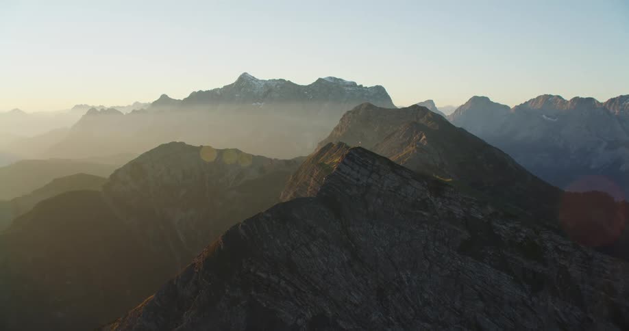 A foggy mountain ridge under a clear daytime sky