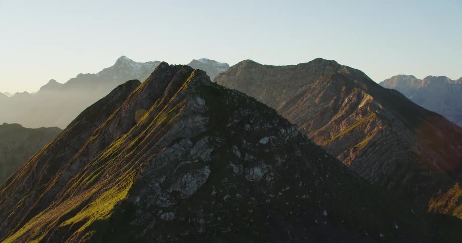 A light fog rises in between peaks of a mountain range