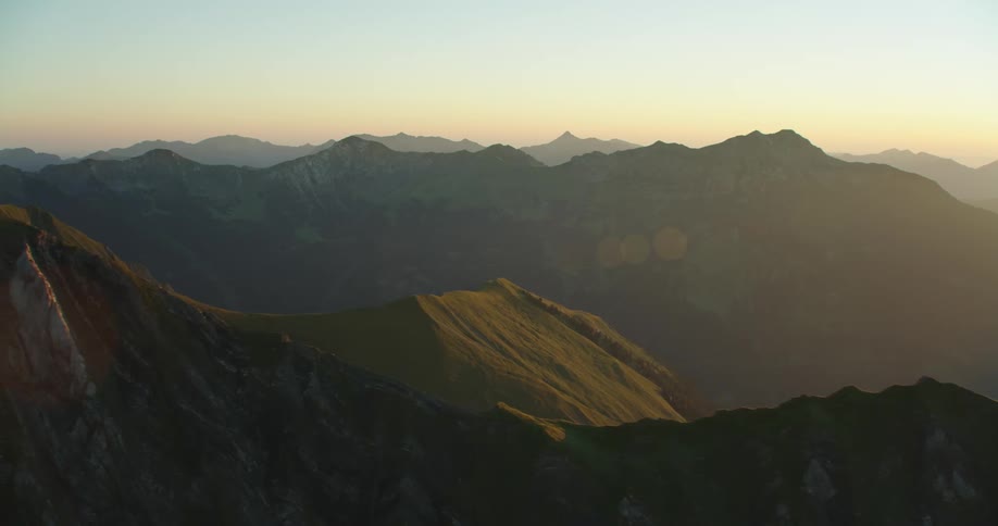 A stone mountain range covered in light fog in the evening