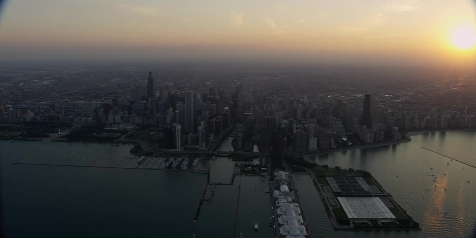 Aerial view of a big city on the edge of water at sunset