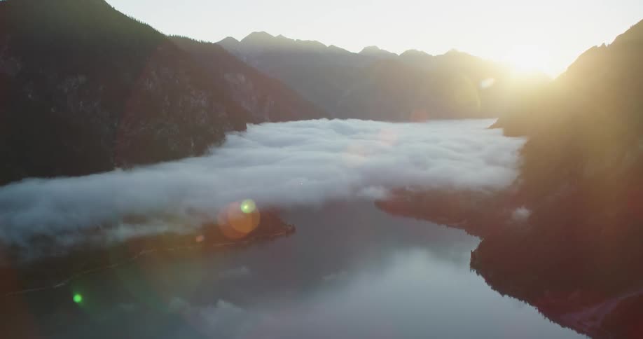 Low clouds floating above a river in a mountain valley during the day
