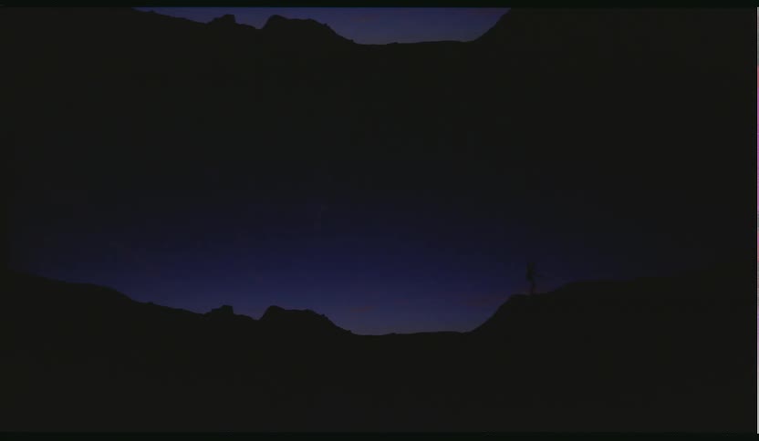 A person doing yoga on a hill outside at night