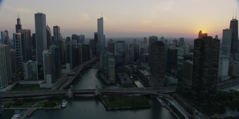 A city with large skyscrapers and a bridge going over a river