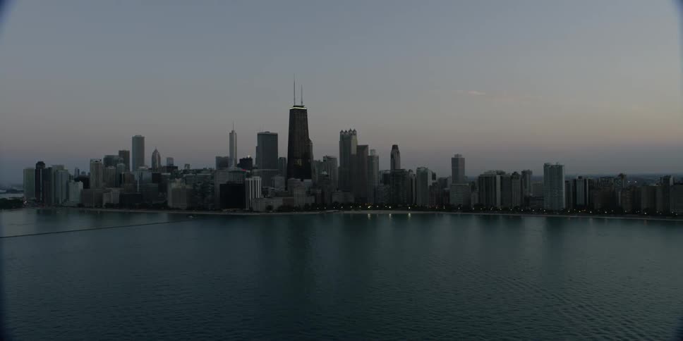 Moving past a city over the water at sunset