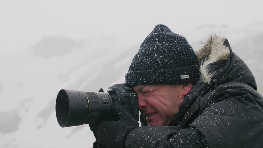 A man is taking pictures in an arctic area