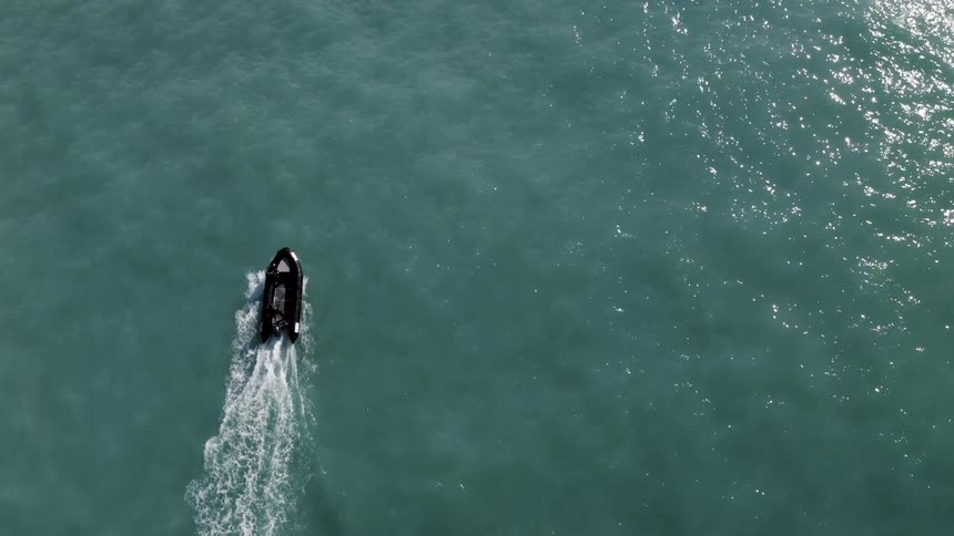 Black boat travels on the ocean water