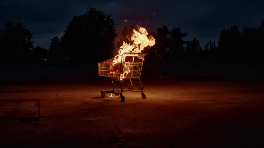 A cart is set on fire outdoors at night