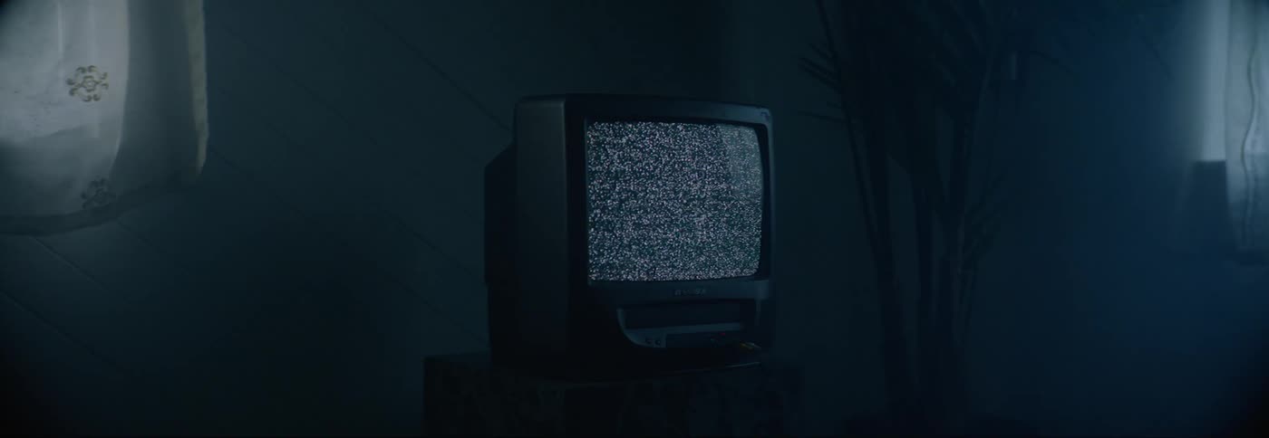 An old crt television on a marble stand displays static
