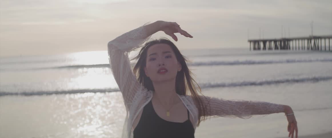 A woman is dancing on the beach
